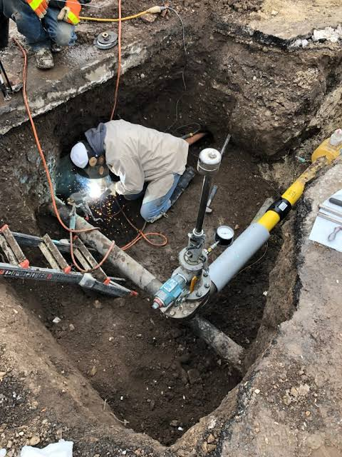 Steel distribution pipeline work inside a protected excavation